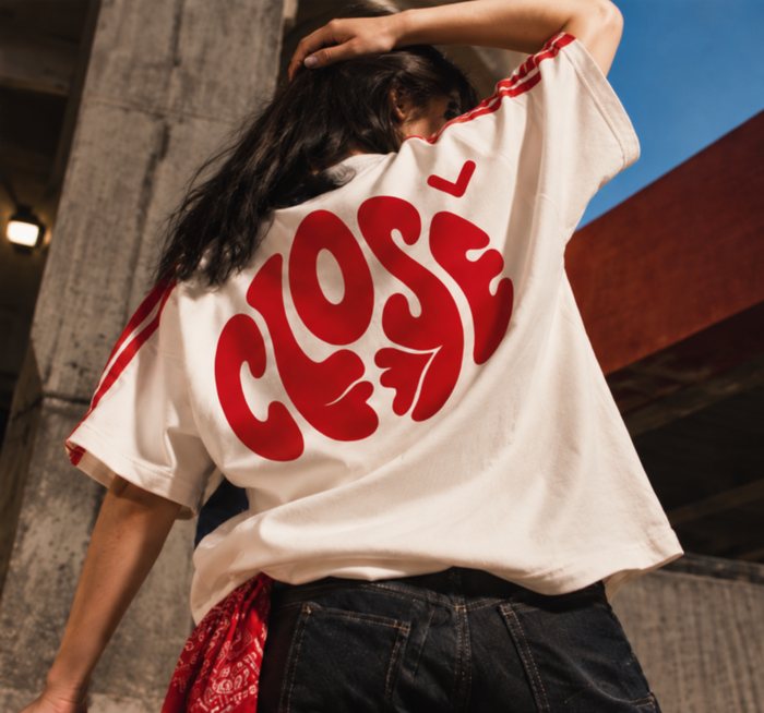 Costas de uma camiseta off-white com o logo Close grande em vermelho